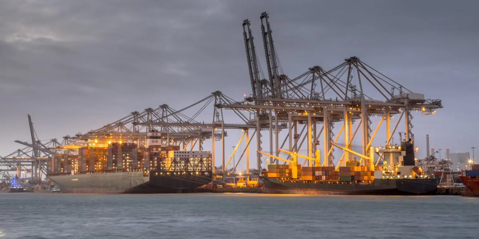 Container cranes and ships at a port terminal at dusk